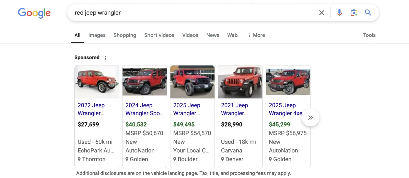 Google desktop search results page for the query "red jeep wrangler," showing a horizontal row of sponsored listings for various red Jeep Wrangler vehicles. Listings include models from 2021 to 2025, with prices ranging from $27,699 to $49,495. Each entry displays a red Jeep vehicle, the year and model, price, condition (new or used), dealership, and location.
