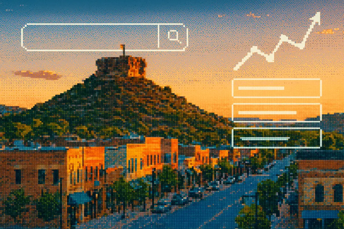 Pixelated panoramic view of a historic town nestled at the foot of a mountain, bathed in the warm light of the setting sun. The image includes a search bar icon.